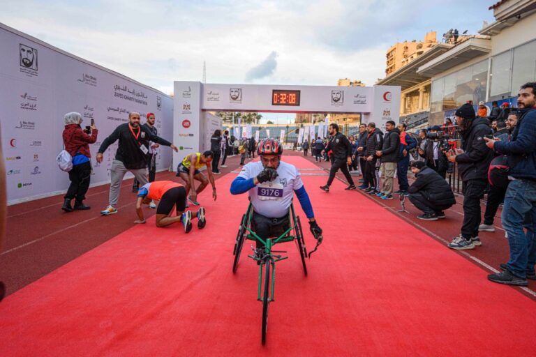 A wheelchair participant racing past the finish line at Zayed Charity Marathon Egypt 2022